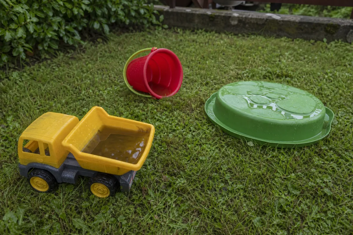 Jouets d’enfant laissés dehors remplis d’eau de pluie
