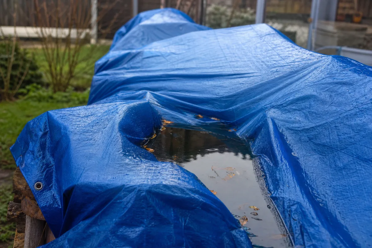 Bâche bleue formant des poches d’eau de pluie