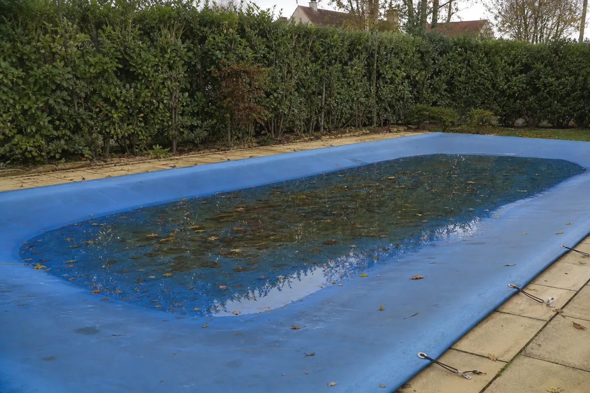 Couverture de piscine où stagne de l’eau de pluie, gîte à moustiques